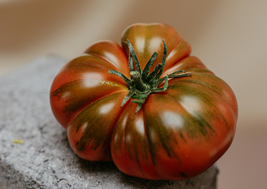 Tomate raf maduro robre una piedra - Foto de Cup of  Couple de Pexels: https://www.pexels.com/es-es/foto/fruta-fresco-tomate-verdura-7657315/